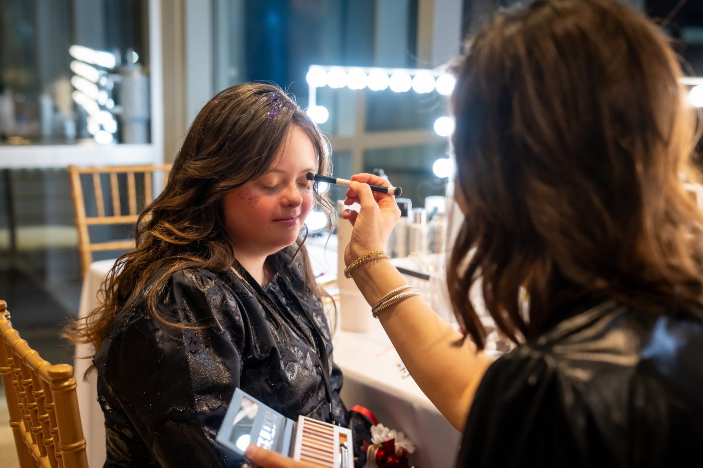 An honored guest having makeup applied before Night to Shine